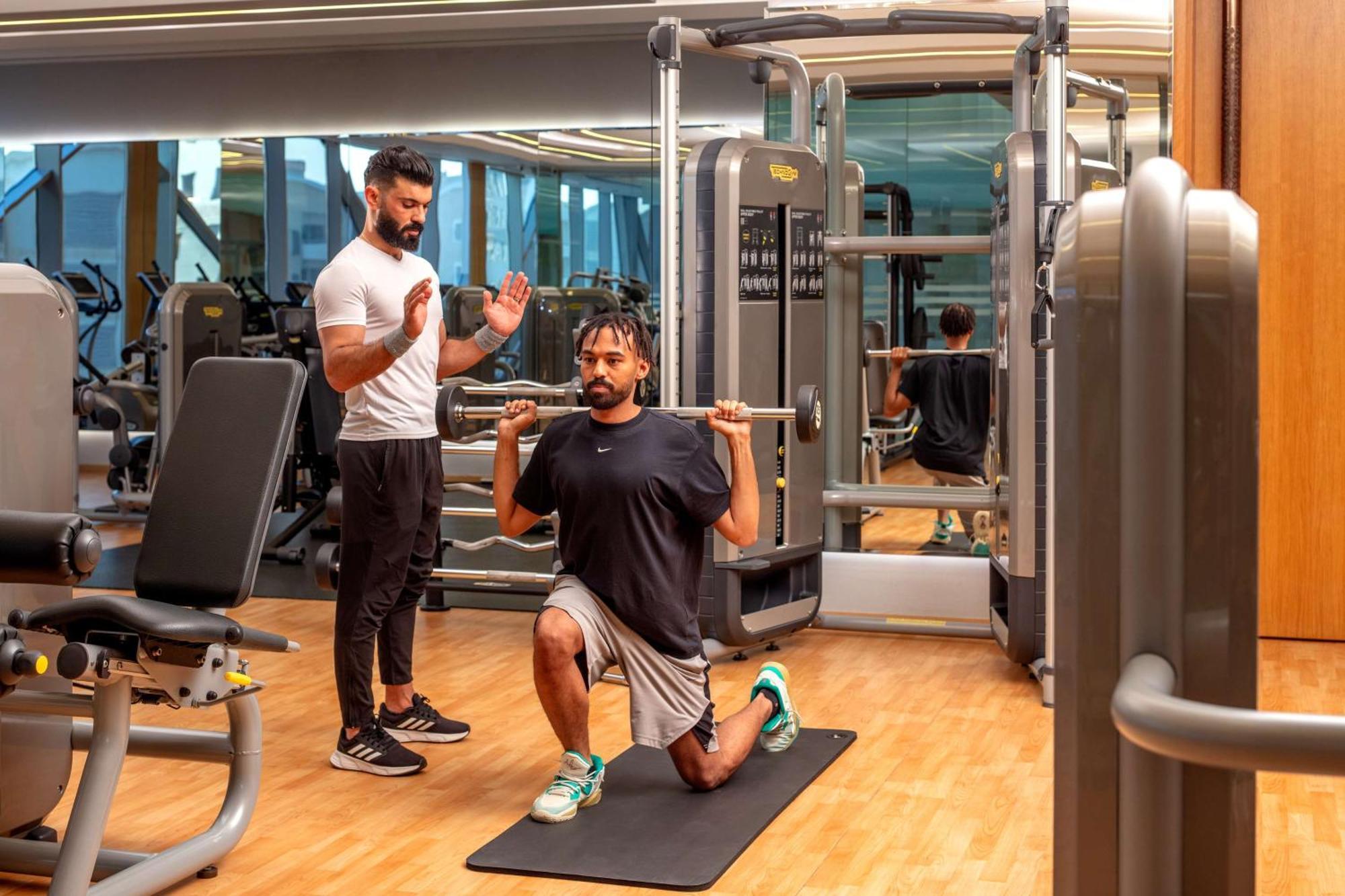 Hyatt Regency Riyadh Olaya Экстерьер фото Personal trainer coaching a man on a Bulgarian split squat